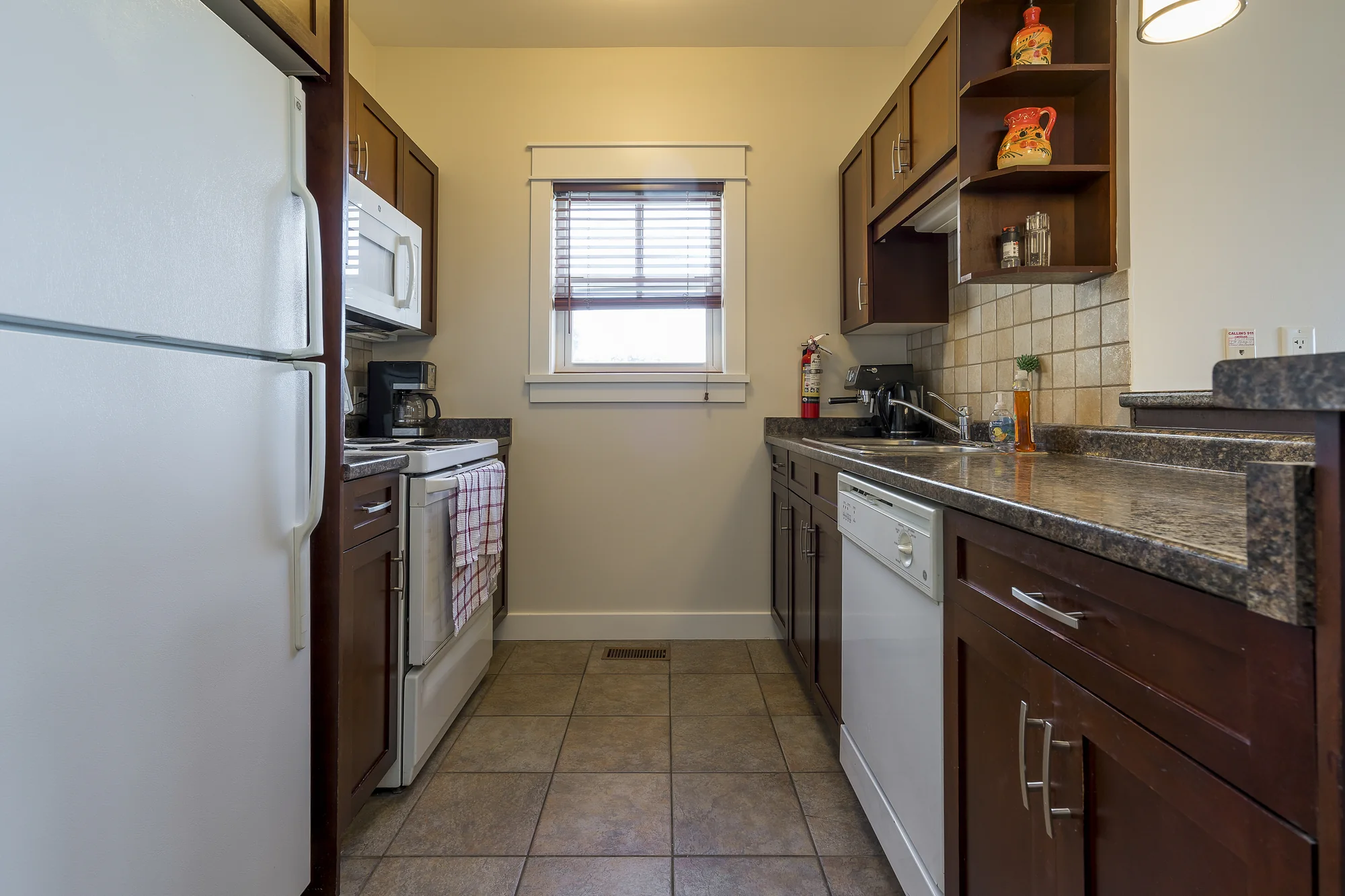 Open kitchen with stainless appliances and cooking essentials